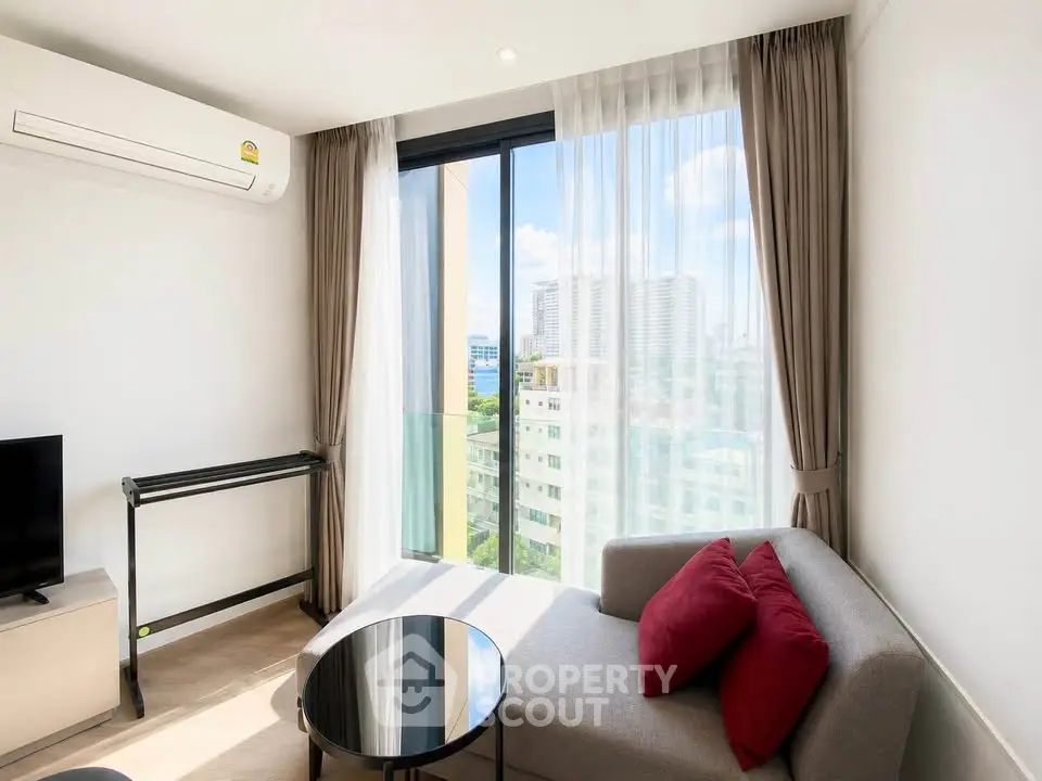 Modern living room with city view, featuring a cozy sofa and sleek decor.