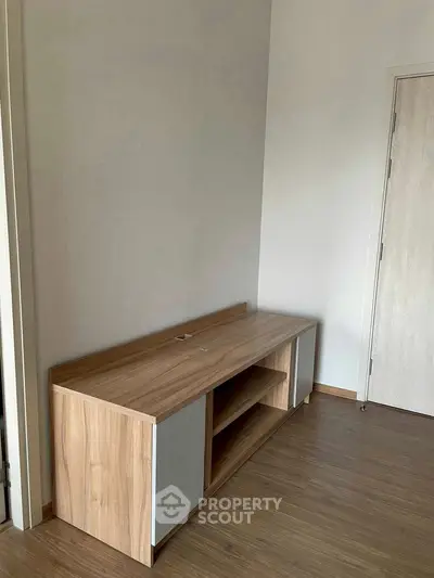 Modern wooden storage unit in a minimalist room with wooden flooring.