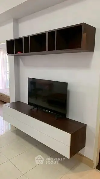 Modern living room with sleek TV unit and wall-mounted shelves
