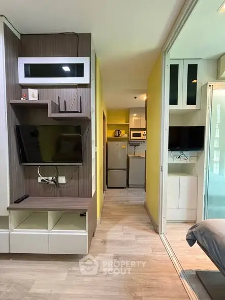 Modern studio apartment with open layout, featuring a compact kitchen and stylish living area.