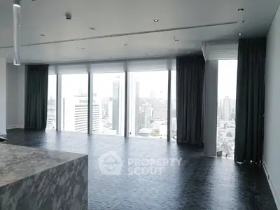 Spacious modern living room with panoramic city views and elegant marble accents.