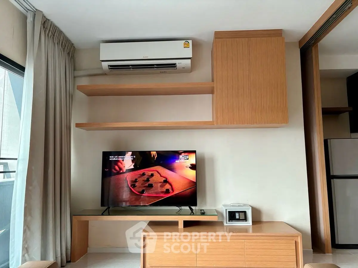Modern living room with air conditioning and TV, featuring sleek wooden shelves and cabinets.
