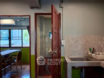 Charming kitchen with adjacent dining area and bathroom, featuring modern fixtures and natural light.