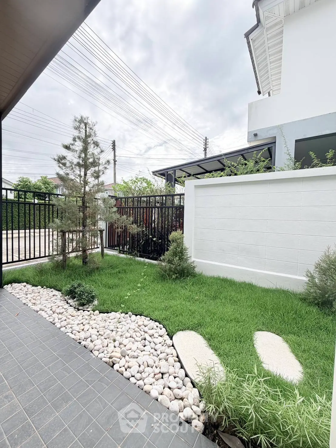 Charming garden view with lush greenery and modern fencing in a serene residential area.