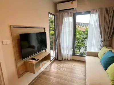 Modern living room with large window and wall-mounted TV, featuring cozy sofa and lush garden view.