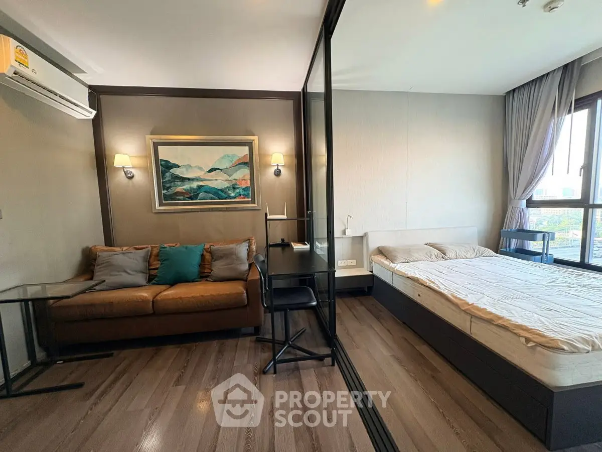 Modern studio apartment with cozy living area and stylish bedroom, featuring large windows and elegant decor.