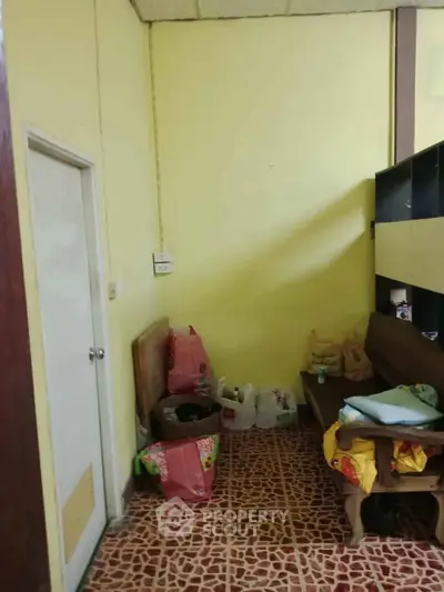 Cozy interior space with tiled floor and wooden furniture, ideal for storage or small living area.