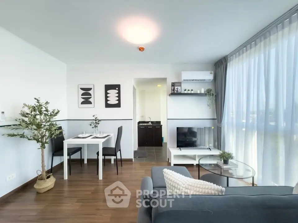 Modern living room with elegant decor and large windows offering natural light