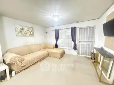 Spacious living room with cozy L-shaped sofa and modern decor, perfect for relaxation.