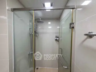 Modern bathroom with glass shower enclosure and sleek fixtures