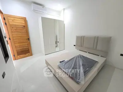 Modern minimalist bedroom with sleek furniture and wooden accents