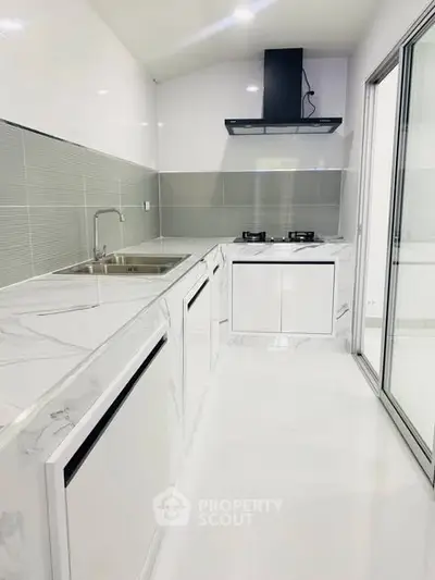 Sleek modern kitchen with marble countertops and gas stove