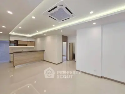 Spacious modern living room with open kitchen and sleek ceiling design