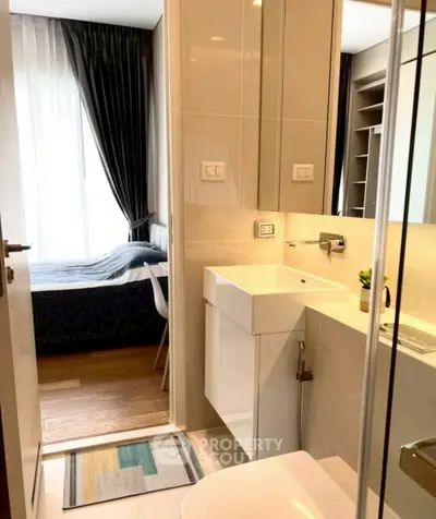 Modern compact bathroom with sleek design and adjacent bedroom view.