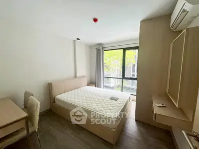 Modern bedroom with large window and minimalist furnishings