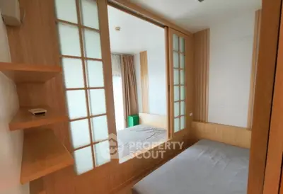 Modern bedroom with sliding glass doors and wooden accents, creating a cozy and stylish living space.