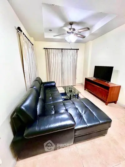 Cozy living room with leather sectional sofa and modern entertainment center.