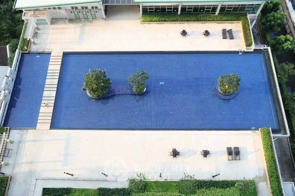 Luxurious rooftop pool with lush greenery and modern design, perfect for relaxation and leisure.