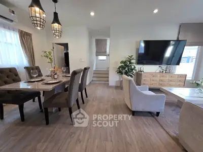 Spacious modern living room with elegant dining area and large TV, perfect for family gatherings.