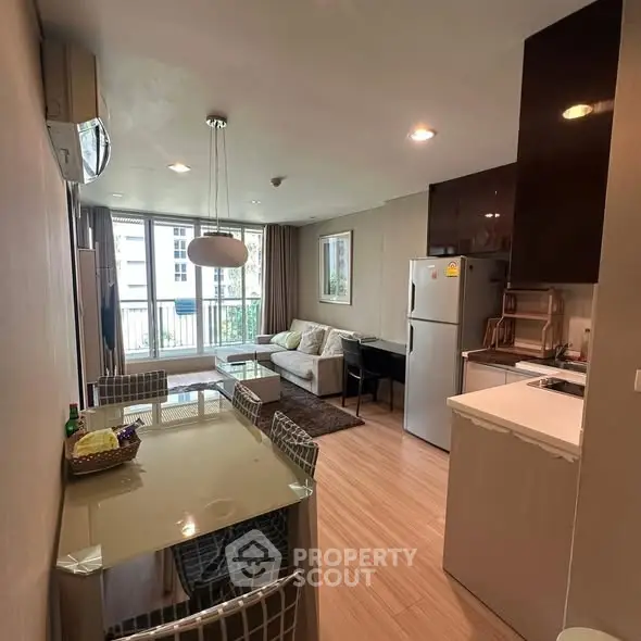 Modern open-layout living room and kitchen with stylish decor and natural light.