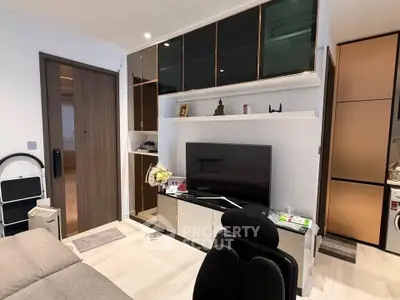 Modern living room with sleek furniture and built-in storage, showcasing contemporary design and functionality.