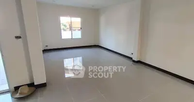 Spacious empty room with glossy tiled floor and large window