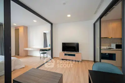 Modern open-plan living room with sleek wooden flooring and stylish furniture in a contemporary apartment.