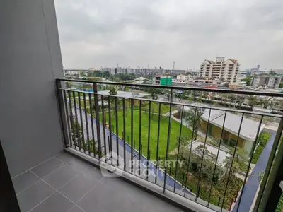 Spacious balcony with stunning cityscape view and lush greenery, perfect for relaxation.