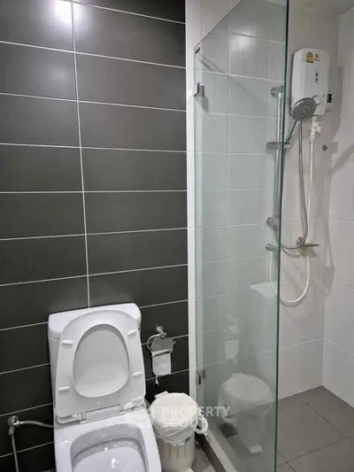 Modern bathroom with sleek shower and toilet in contemporary design.