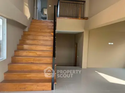 Modern interior with wooden staircase and open living space, perfect for contemporary living.