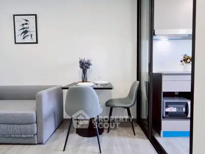 Modern living room with sleek furniture and adjacent kitchen area in a stylish apartment.