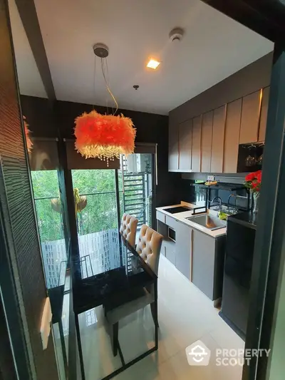 Modern kitchen with sleek cabinetry and stylish dining area in a compact layout