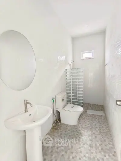 Modern minimalist bathroom with sleek fixtures and bright white tiles.