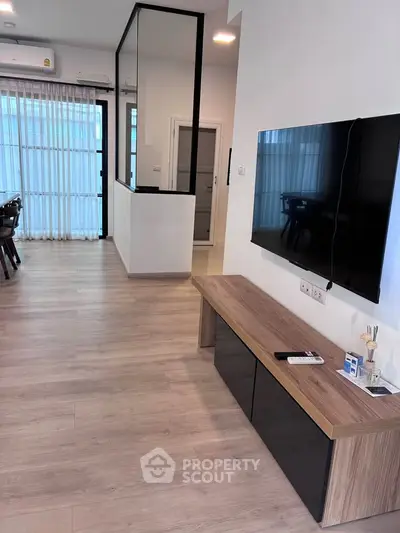 Modern living room with sleek TV setup and stylish wooden flooring