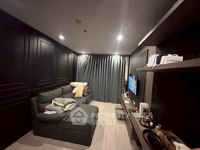 Modern living room with sleek black walls, cozy gray sofa, and stylish shelving unit.