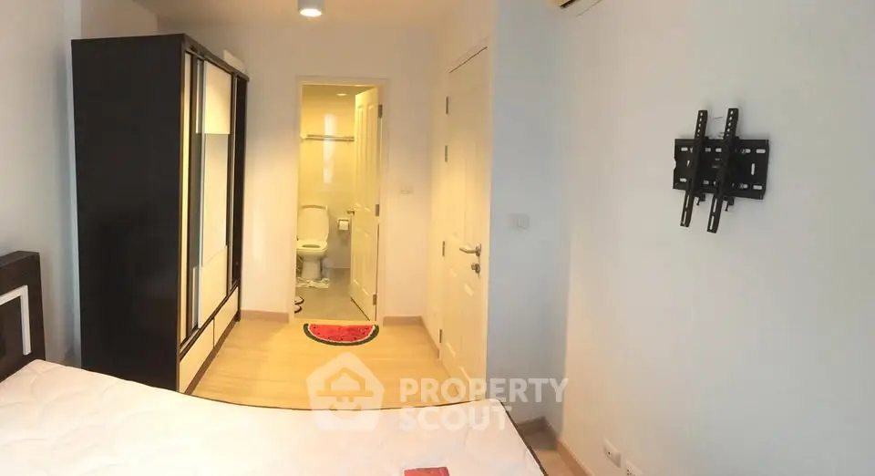 Modern bedroom with ensuite bathroom and wall-mounted TV bracket, featuring sleek wardrobe and minimalist design.