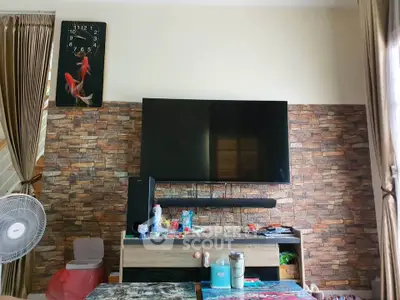 Cozy living room with modern TV setup and stylish stone accent wall