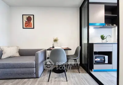 Modern living room with cozy sofa and compact kitchen in open layout apartment.