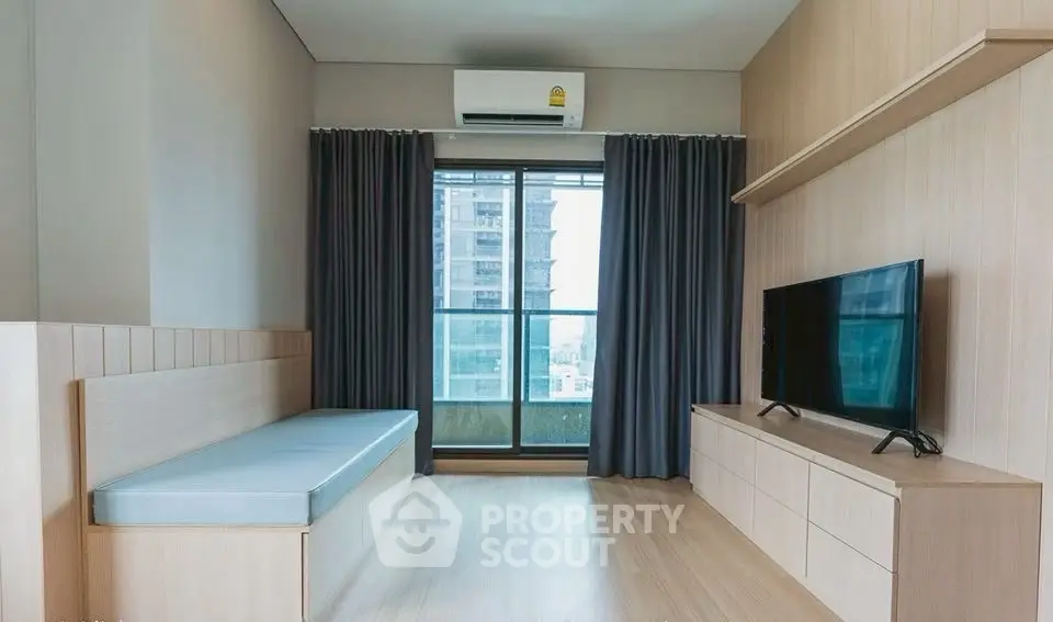 Modern living room with balcony view and sleek TV setup.