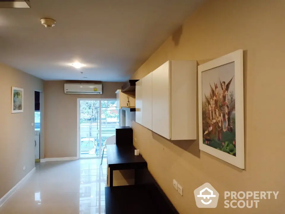 Modern living room with wall art and ample natural light in a stylish apartment.