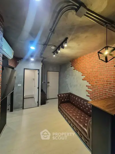 Modern industrial-style living room with exposed brick and leather sofa