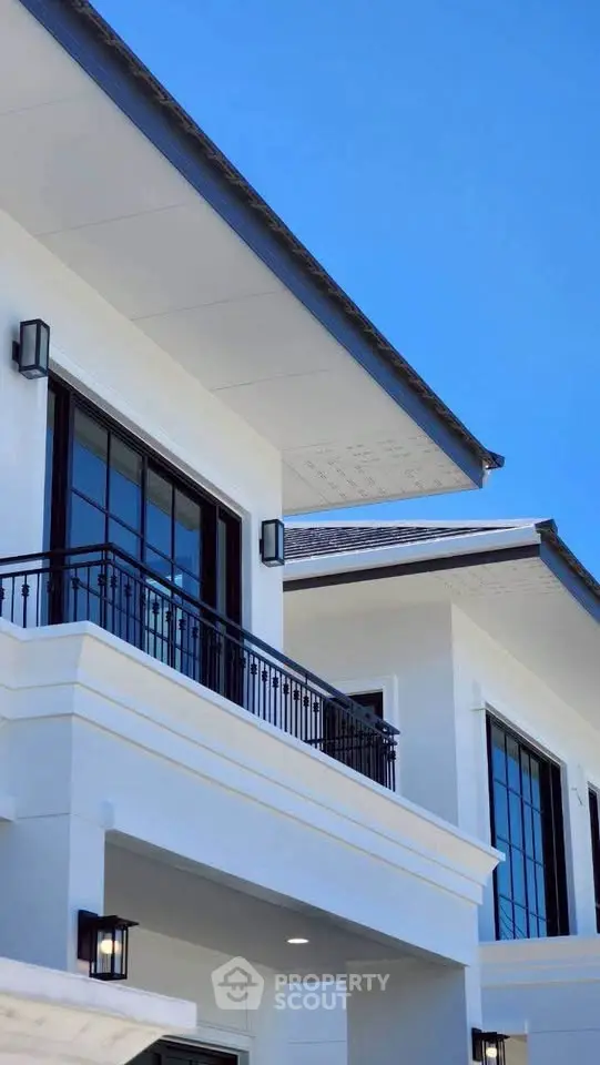 Modern luxury home exterior with sleek balcony and large windows