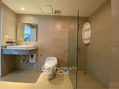 Modern bathroom with glass shower and sleek fixtures in contemporary apartment.