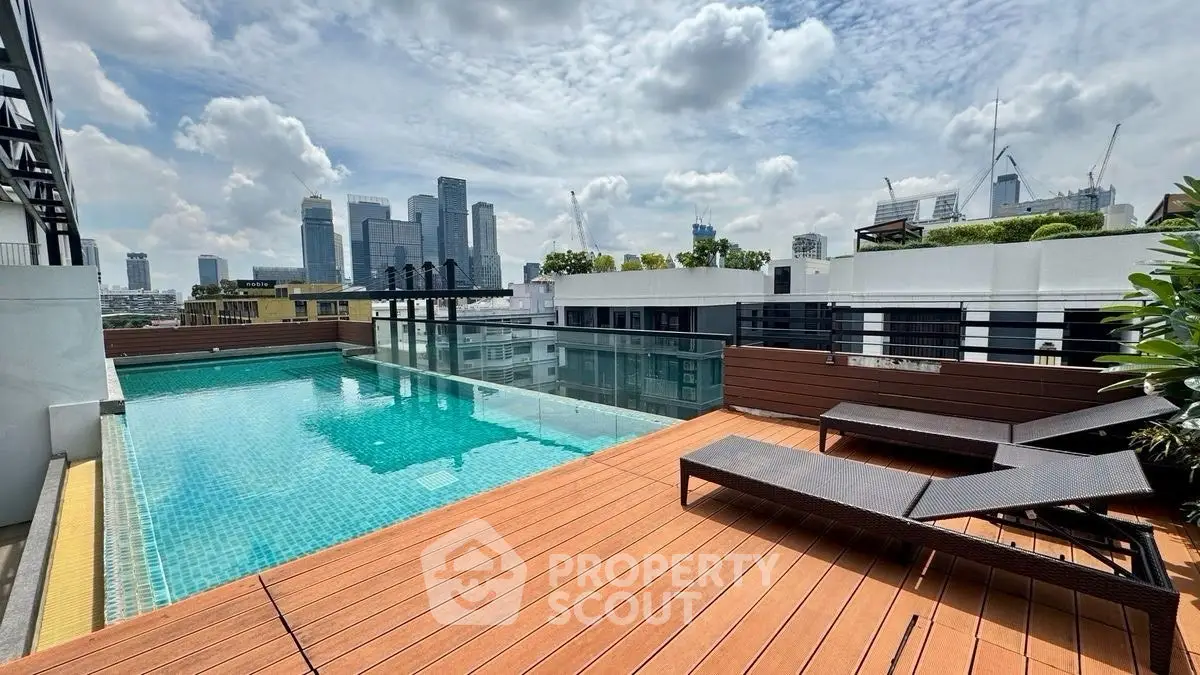 Stunning rooftop pool with city skyline views and modern deck chairs.