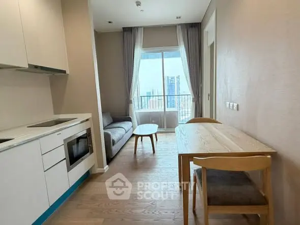 Modern apartment interior with kitchen and living area, featuring city view.
