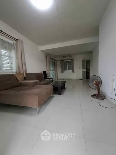 Spacious living room with modern sofa and large windows for natural light.