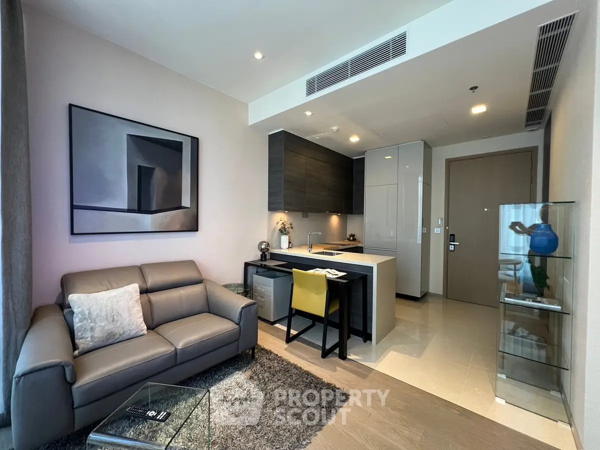 Modern living room with open kitchen, sleek furniture, and stylish decor in a contemporary apartment.