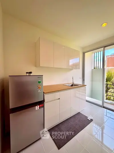 Modern kitchen with sleek cabinets and stainless steel fridge in bright apartment
