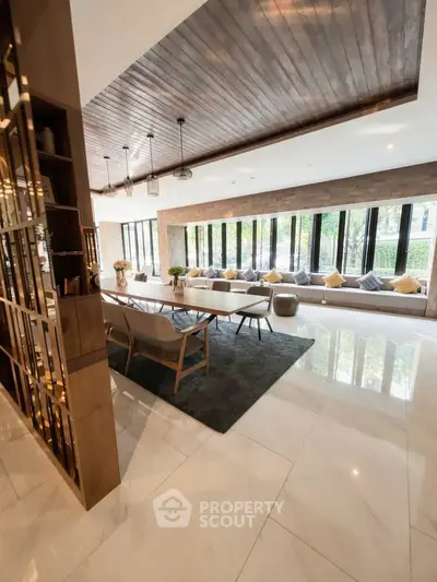 Luxurious modern living room with elegant decor and large windows offering natural light.