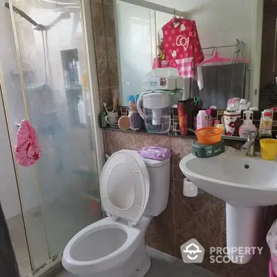 Compact bathroom with essential fixtures, mirrored medicine cabinet, and a variety of personal care products on display.